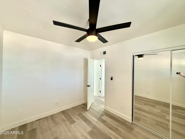 a view of hallway with a ceiling fan and wooden floor