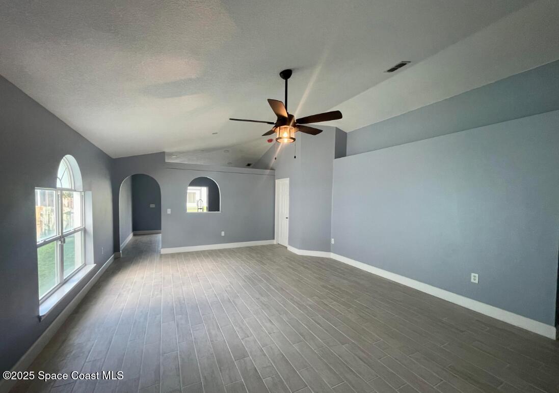 2226 Redwood Circle Palm Bay, FL 32905 - Photo 7 of 27 a view of a livingroom with wooden floor a ceiling fan and windows
