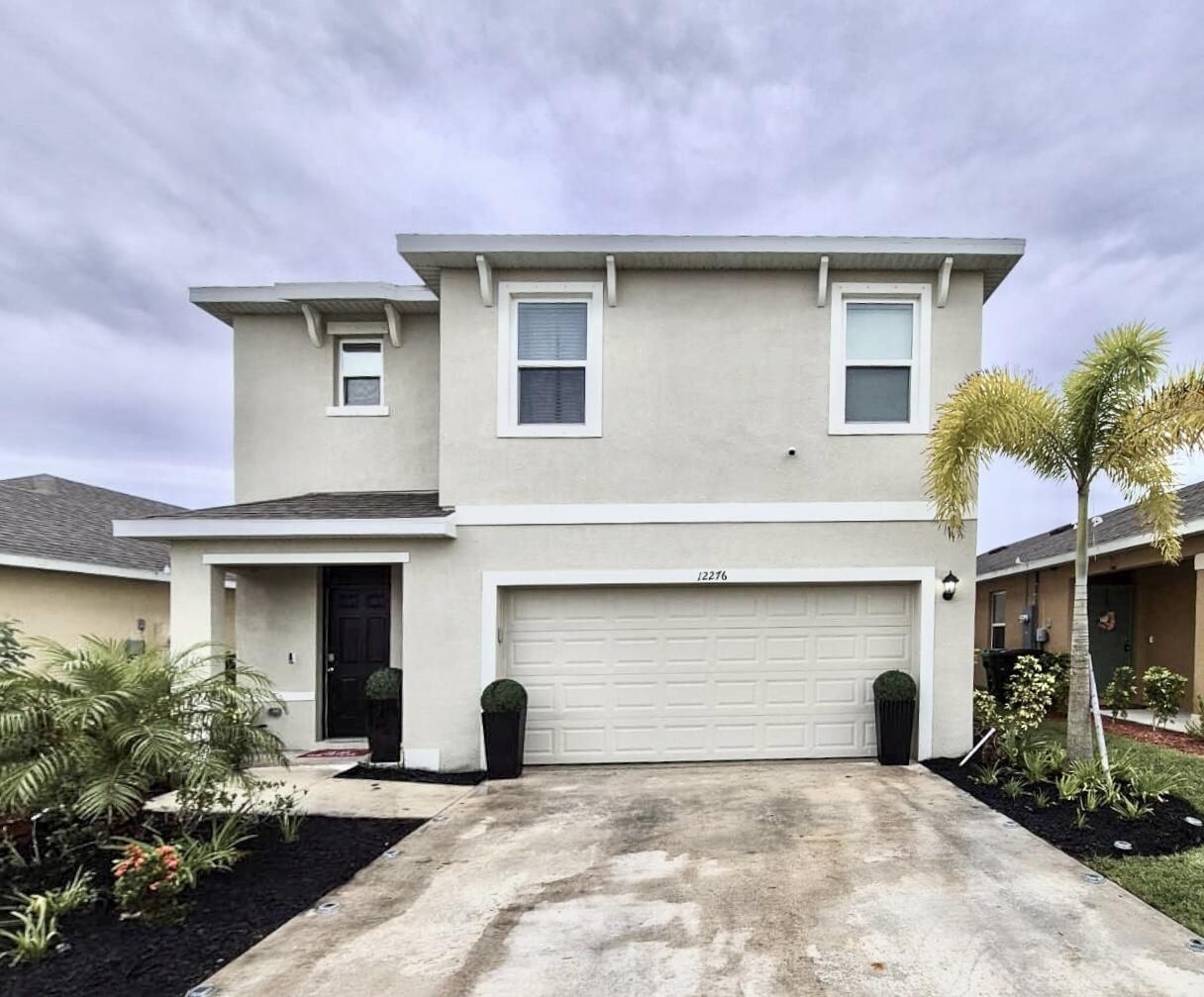 12276 Nettuno Way Port St. Lucie, FL 34987 - Photo 1 of 21 a front view of a house with a yard and garage