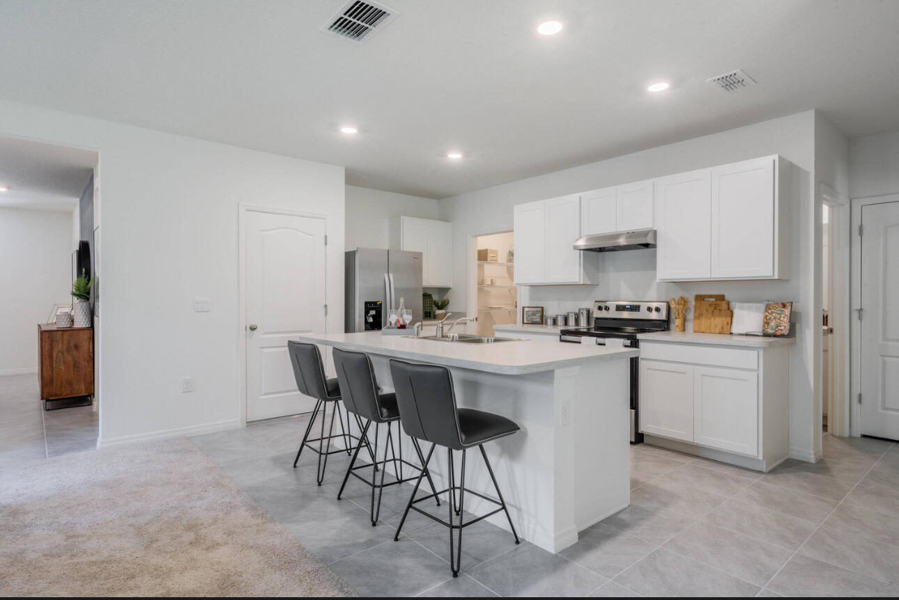 12276 Nettuno Way Port St. Lucie, FL 34987 - Photo 4 of 21 a kitchen with a sink and chairs