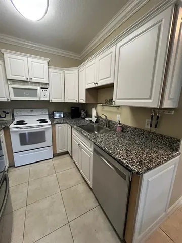 a kitchen with stainless steel appliances granite countertop a sink stove and microwave
