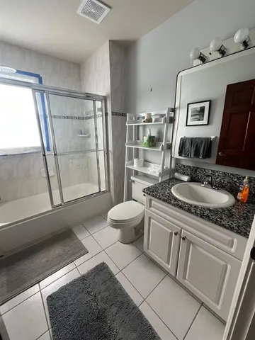 a bath room with a sink a toilet and a mirror