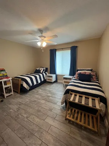 a bedroom with furniture and a ceiling fan