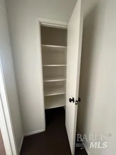 a view of walk in closet with empty racks