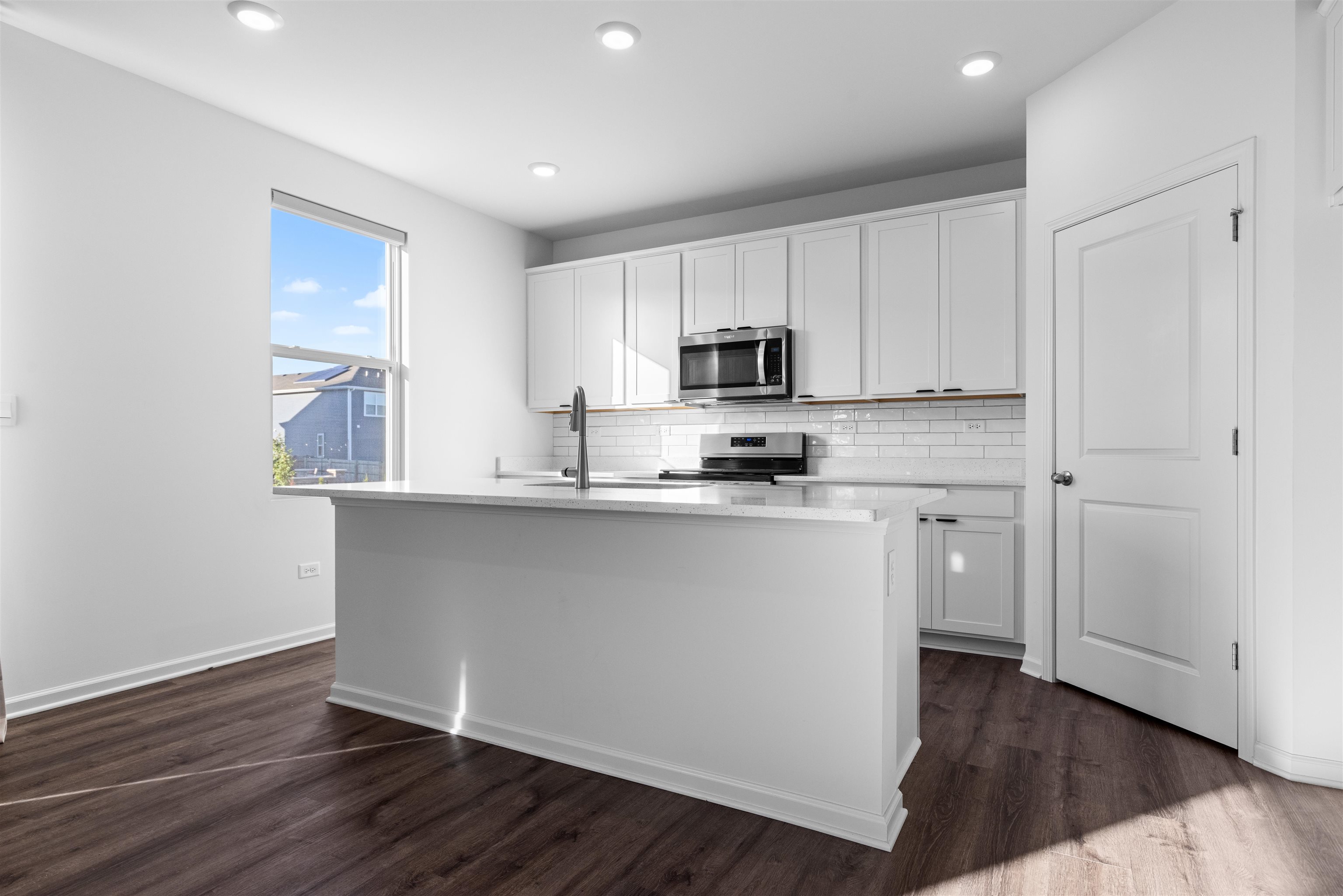 9981 Humbolt Avenue Huntley, IL 60142 - Photo 4 of 23 a kitchen with kitchen island white cabinets a sink and dishwasher with wooden floor