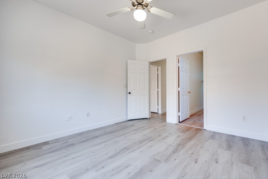 4915 East Russell Road, Unit 127 Las Vegas, NV 89120 - Photo 14 of 19 An airy bedroom with light wood flooring and a modern ceiling fan for comfortable living.