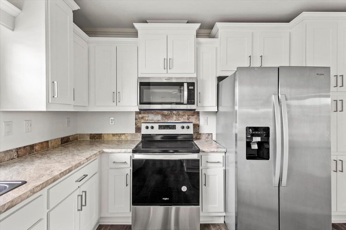 805 Ave B Fort Pierce, FL 34950 - Photo 8 of 29 a kitchen with stainless steel appliances granite countertop a refrigerator stove and white cabinets