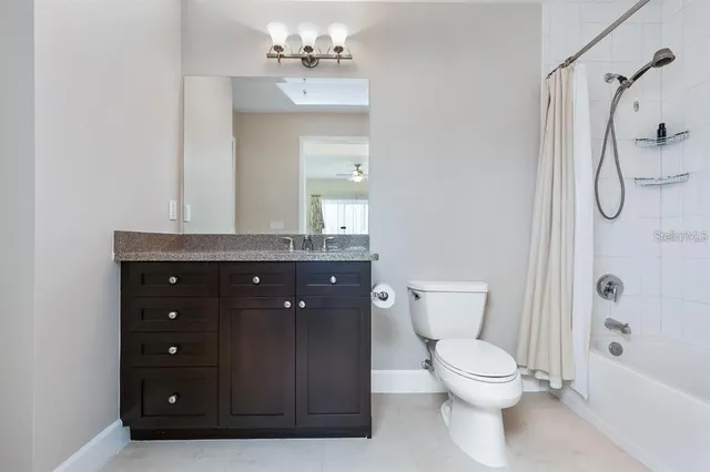 a bathroom with a granite countertop sink a toilet and shower