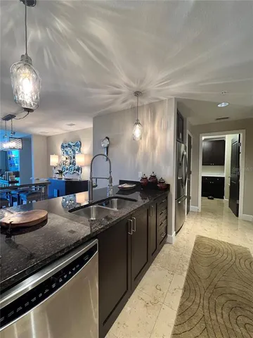 a kitchen with sink and view of living room
