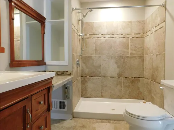 a bathroom with a sink a toilet and shower