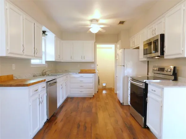 a kitchen with stainless steel appliances a stove a sink a refrigerator and cabinets