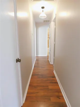 a view of a hallway with wooden floor