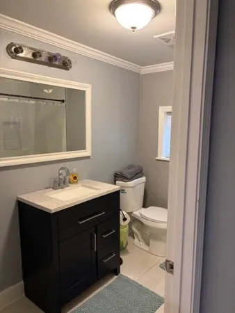 a bathroom with a toilet sink and mirror