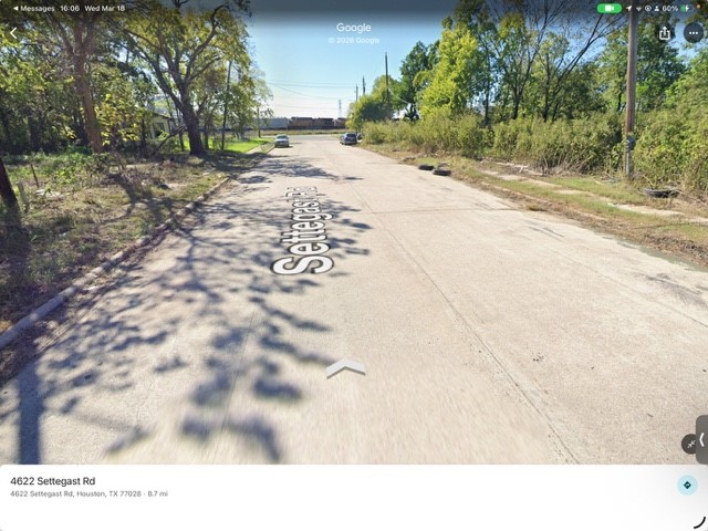 4622 Settegast Road Houston, TX 77028 - Photo 4 of 5 This photo shows a paved road, lined with trees and greenery on both sides.