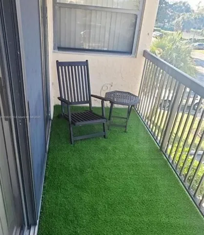 a view of a porch with a bench and wooden fence