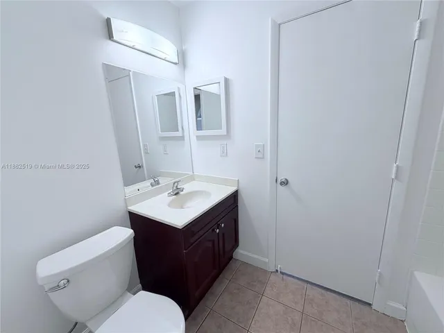 a bathroom with a sink toilet vanity and mirror
