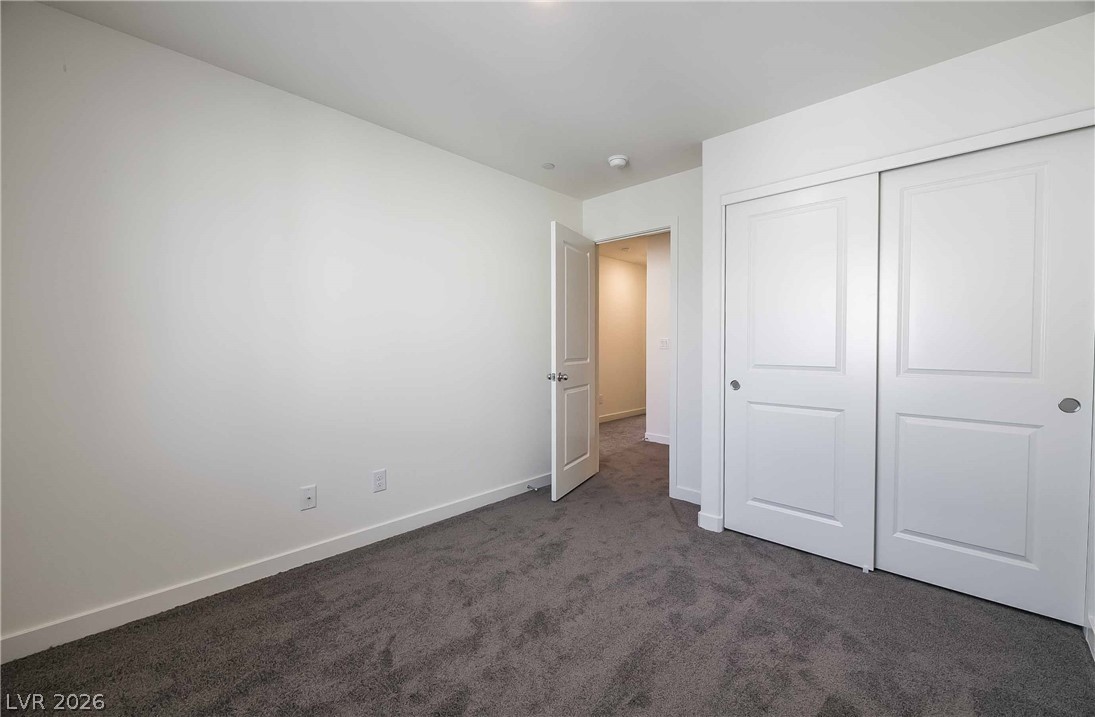 12749 Epperly Street Henderson, NV 89044 - Photo 15 of 22 A well-lit bedroom features plush carpeting and convenient sliding closet doors.