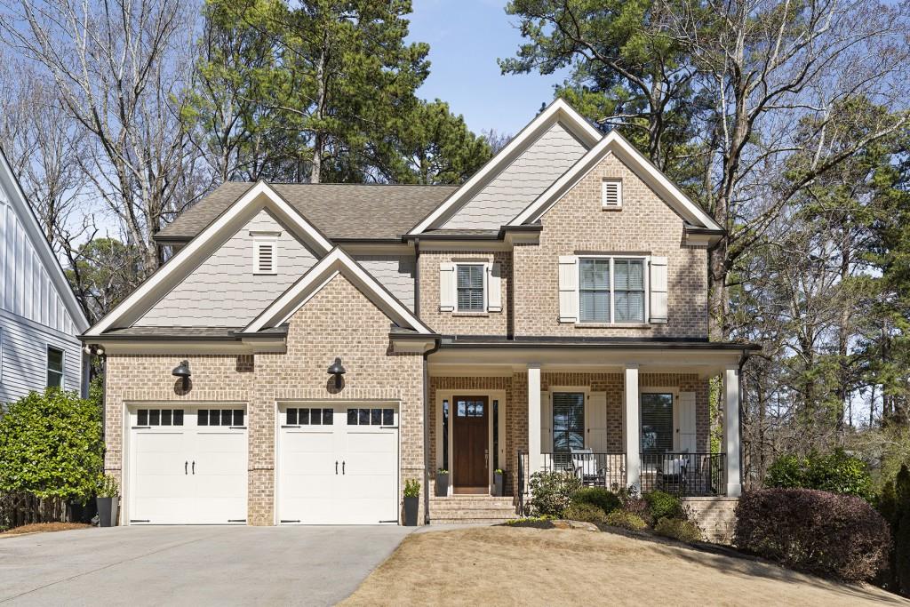 a view of a white house with large windows and a small yard