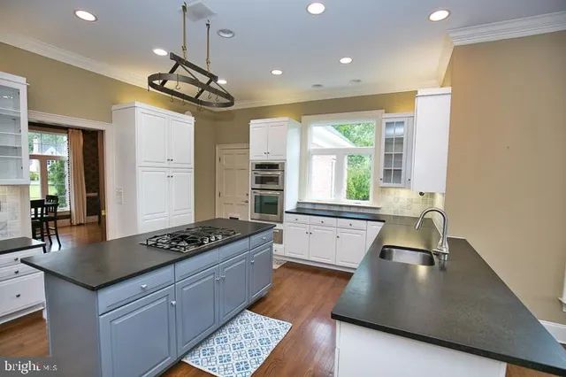 a view of kitchen with furniture and a chandelier fan