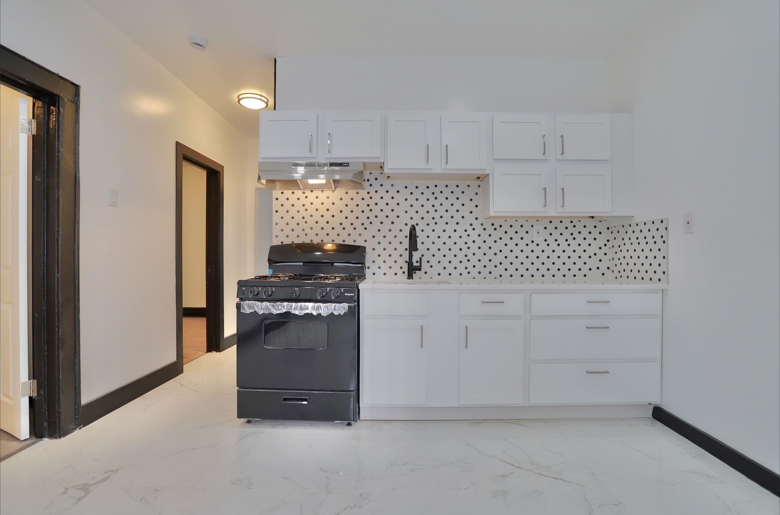 445 South 15th Street Newark, NJ 07103 - Photo 11 of 41 a kitchen with white cabinets and appliances