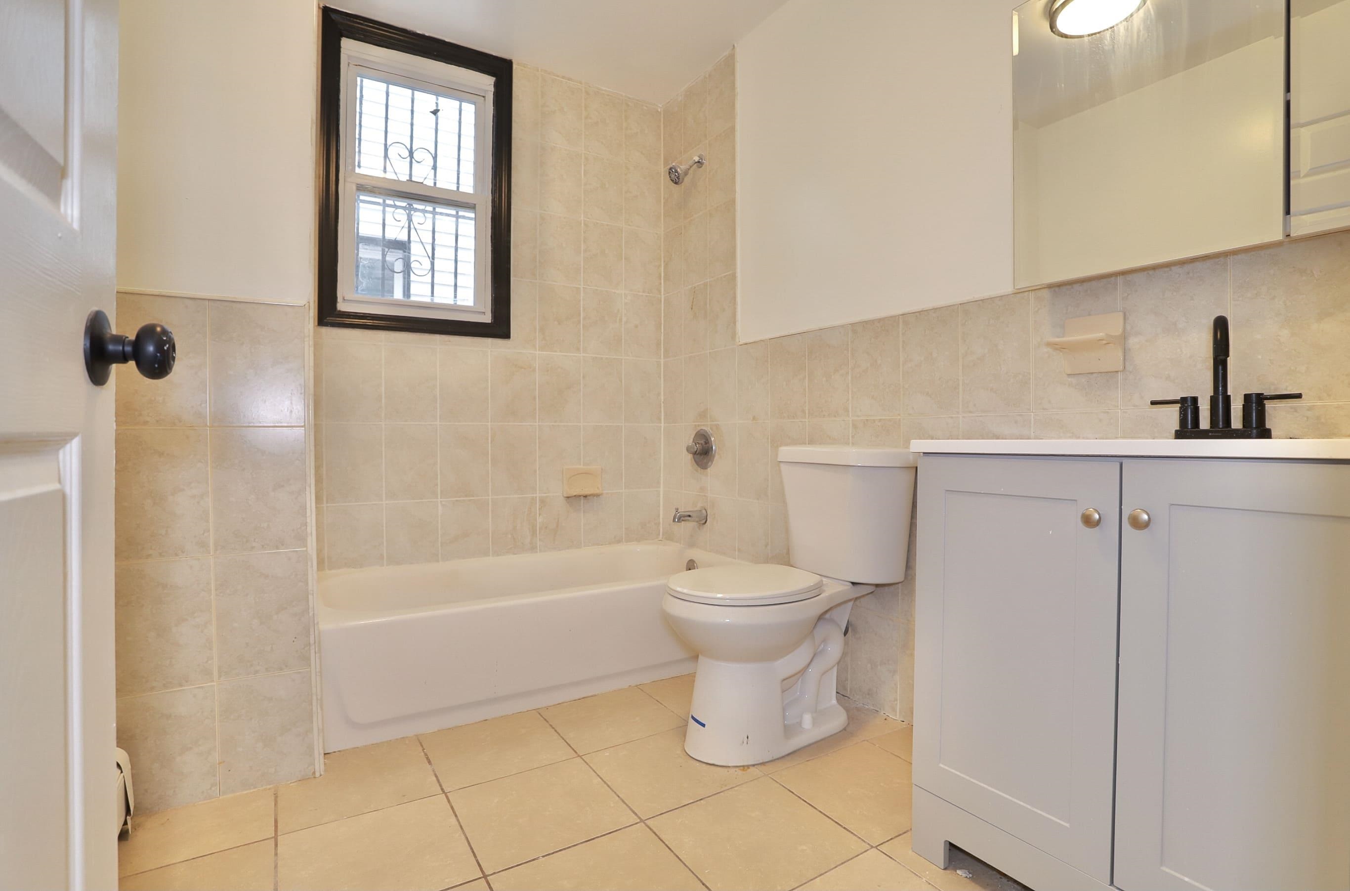 445 South 15th Street Newark, NJ 07103 - Photo 16 of 41 a bathroom with a toilet a sink a window and bathtub