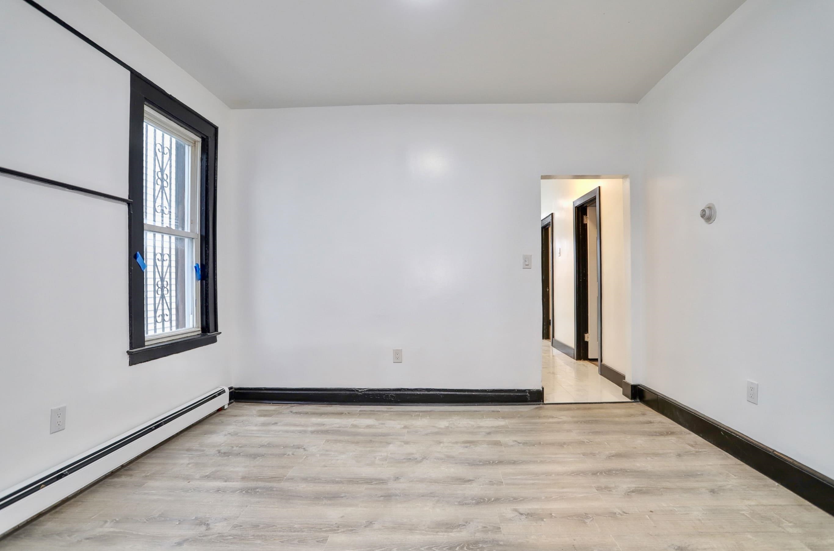 445 South 15th Street Newark, NJ 07103 - Photo 7 of 41 a view of an empty room with wooden floor and a window