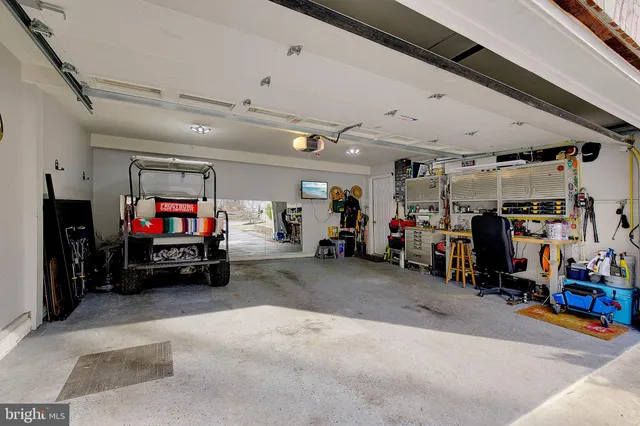 a view of a kitchen with kitchen island stainless steel appliances a large counter top and couch