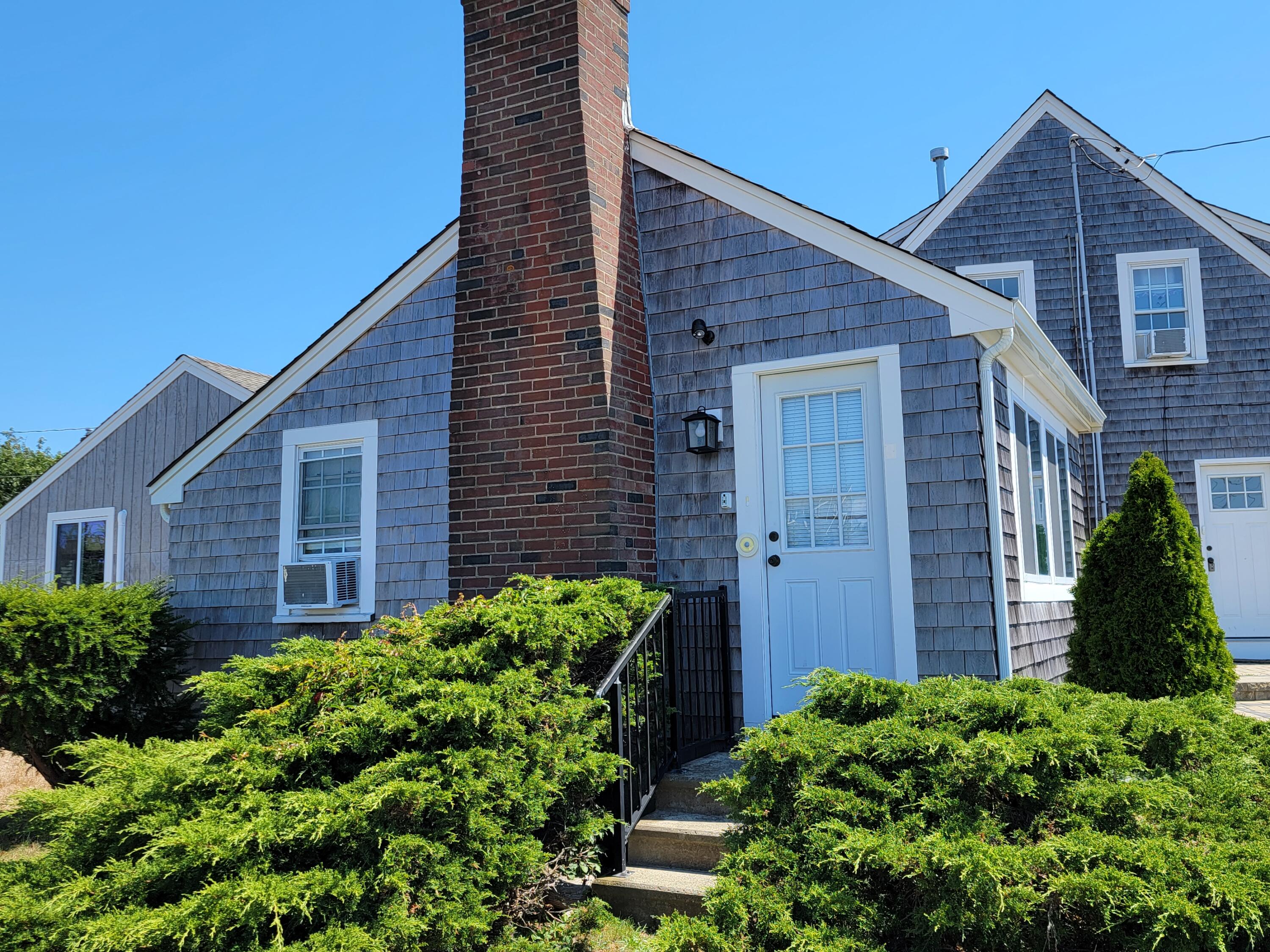 1060 Craigville Beach Road Centerville, MA 02632 - Photo 16 of 50 a view of a brick house next to a yard