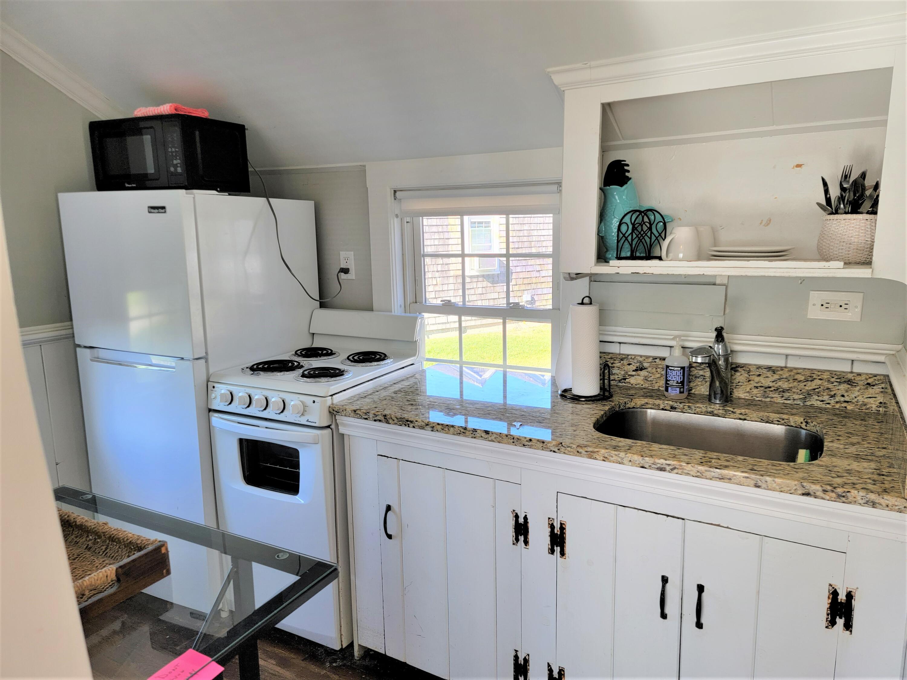 1060 Craigville Beach Road Centerville, MA 02632 - Photo 18 of 50 a kitchen with stainless steel appliances granite countertop a sink a stove a refrigerator and a refrigerator