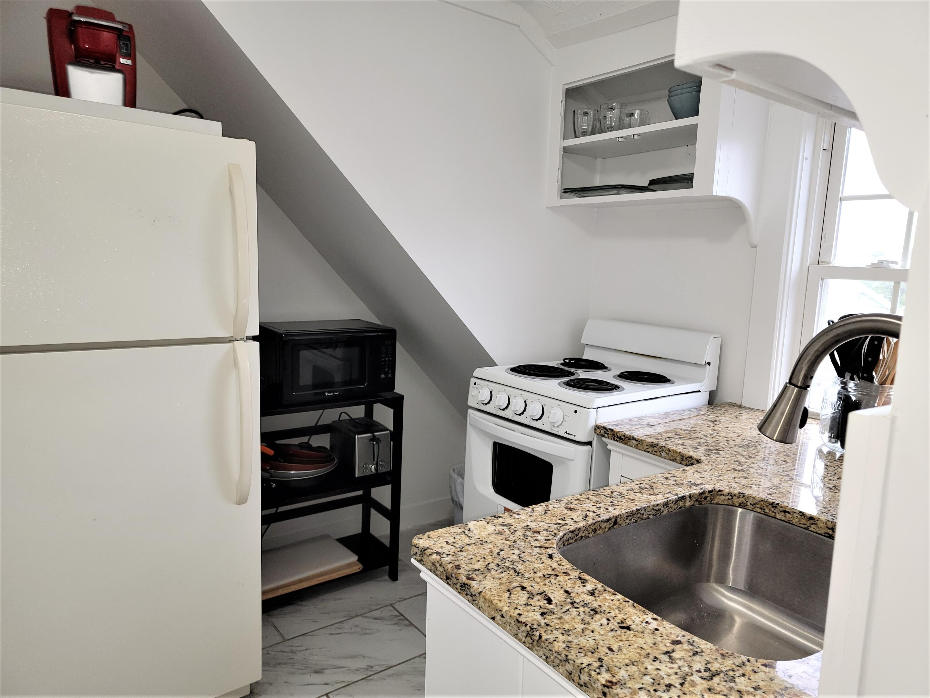1060 Craigville Beach Road Centerville, MA 02632 - Photo 26 of 50 a kitchen with a sink and a stove top oven