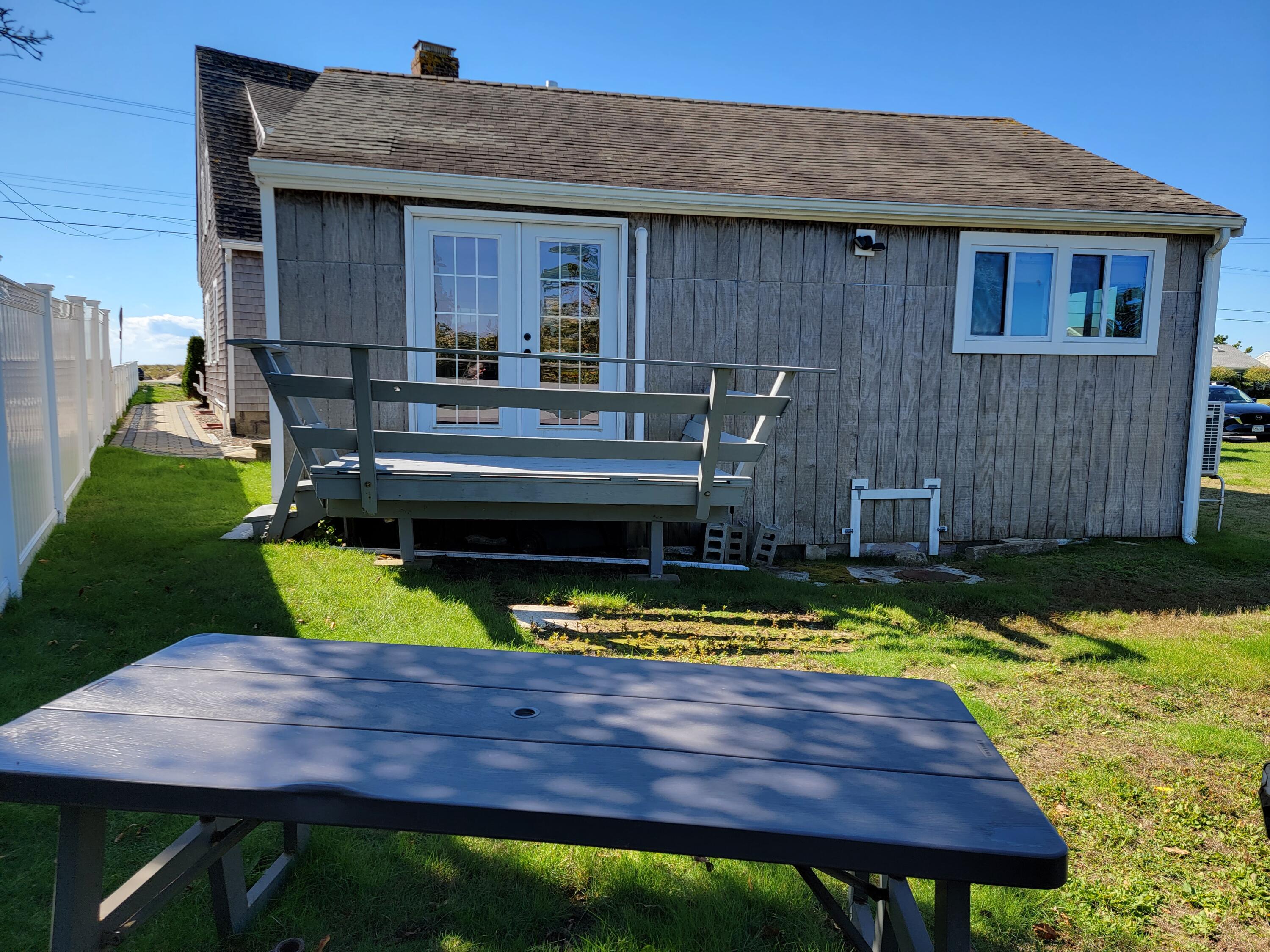 1060 Craigville Beach Road Centerville, MA 02632 - Photo 37 of 50 a view of a backyard with a wooden fence