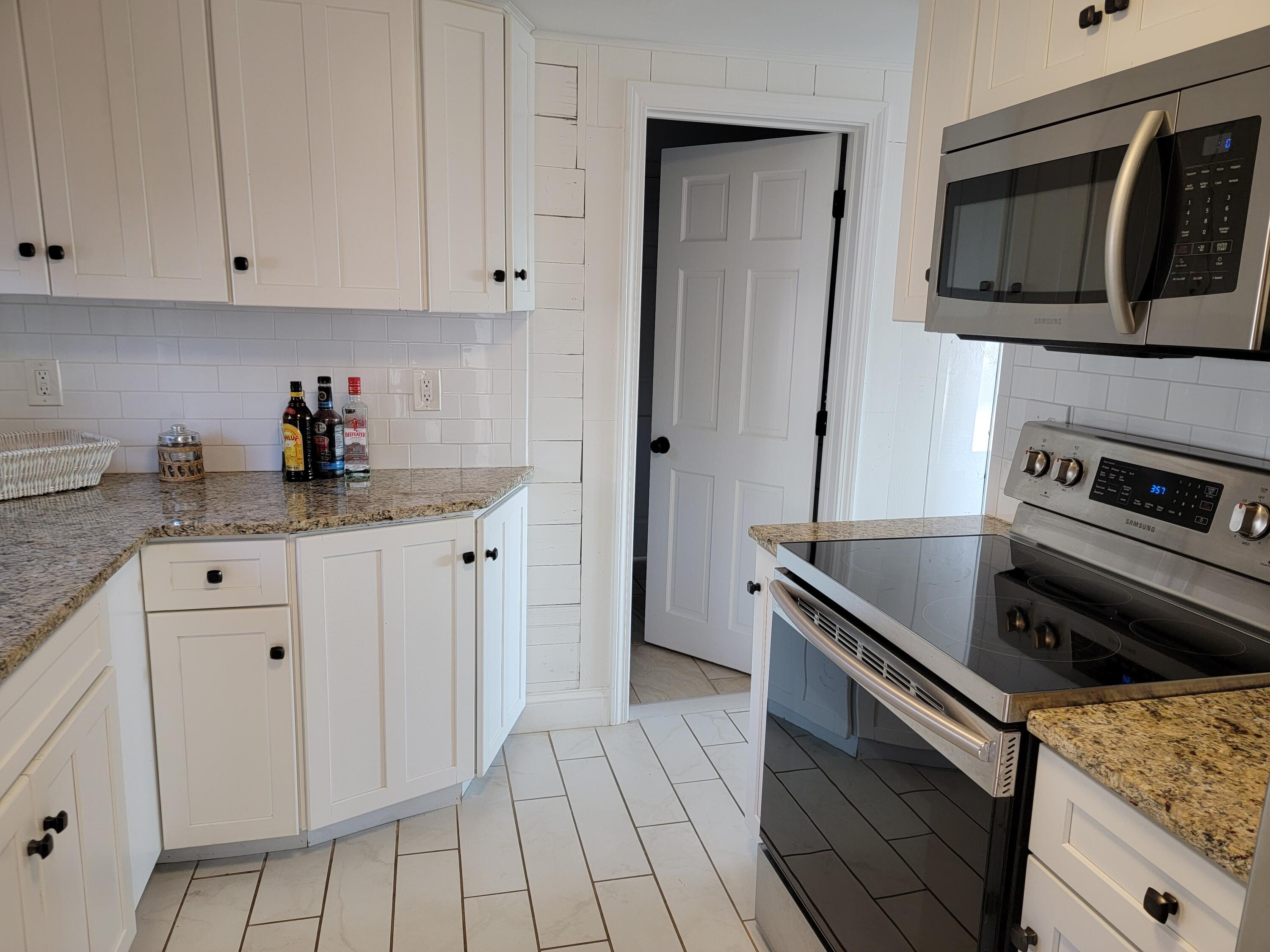 1060 Craigville Beach Road Centerville, MA 02632 - Photo 7 of 50 a kitchen with granite countertop white cabinets and stainless steel appliances