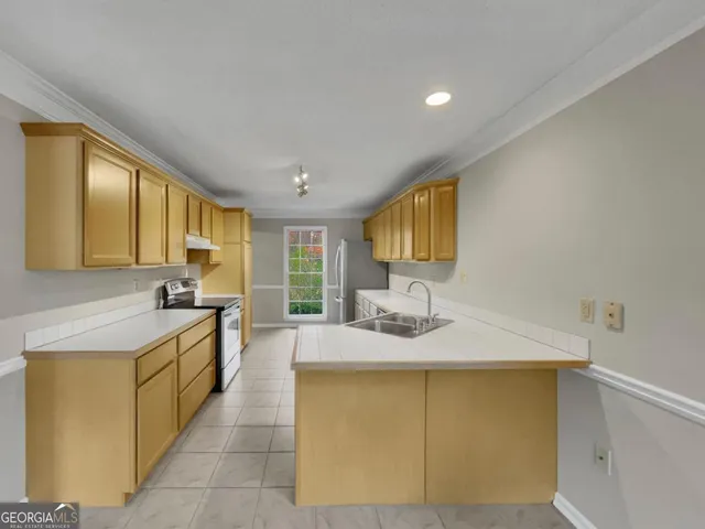 a kitchen with stainless steel appliances granite countertop a refrigerator and a stove