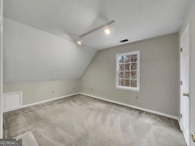 an empty room with windows and closet