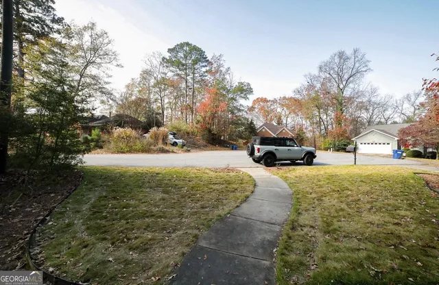 a view of backyard with swimming pool and green space