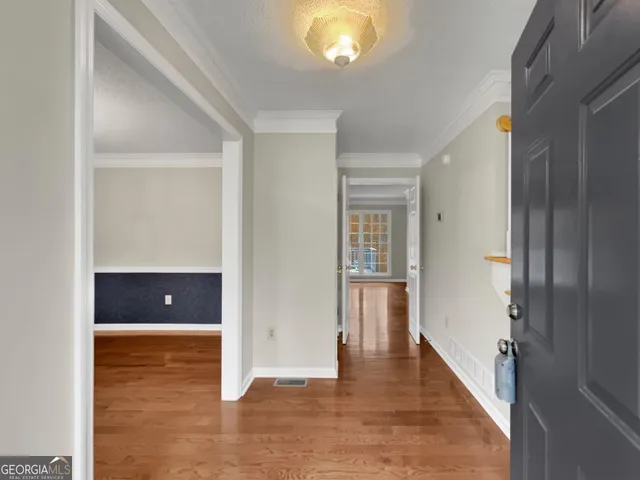 a view of a hallway with wooden floor and front door