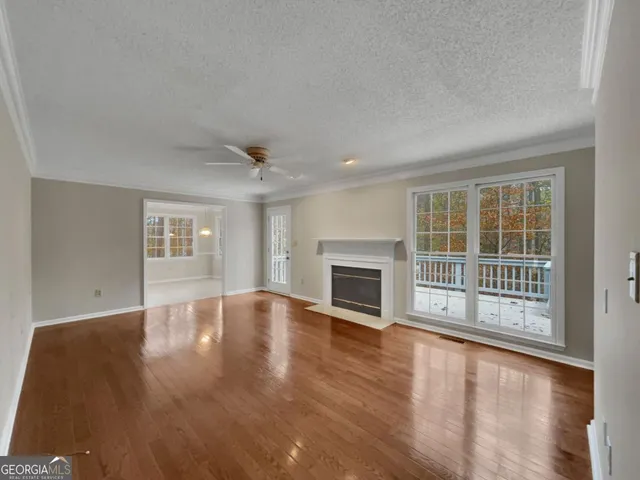 a view of empty room with wooden floor and fireplace