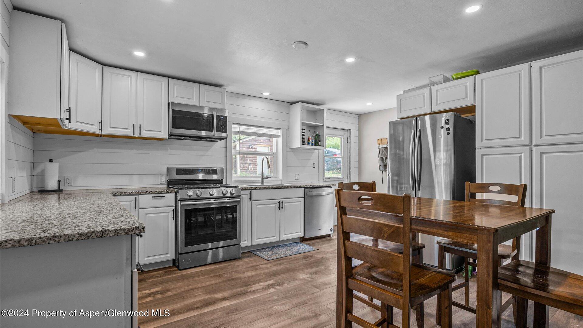 232 East 1st Street Rifle, CO 81650 - Photo 8 of 20 a kitchen with stainless steel appliances granite countertop a stove refrigerator sink and microwave