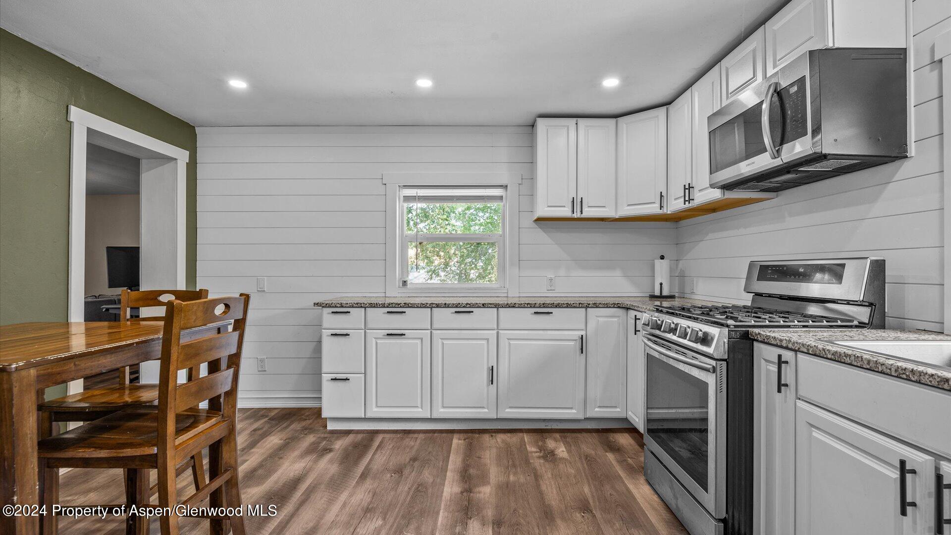 232 East 1st Street Rifle, CO 81650 - Photo 9 of 20 a kitchen with stainless steel appliances granite countertop a stove a sink and a microwave