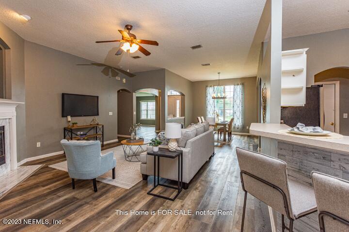 10329 Shelby Creek Road South Jacksonville, FL 32221 - Photo 12 of 41 a living room with furniture and a chandelier