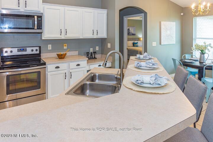 10329 Shelby Creek Road South Jacksonville, FL 32221 - Photo 16 of 41 a kitchen with stainless steel appliances a stove a sink a microwave and cabinets