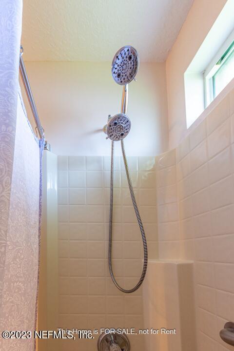 10329 Shelby Creek Road South Jacksonville, FL 32221 - Photo 31 of 41 a bathroom with a shower and a chandelier
