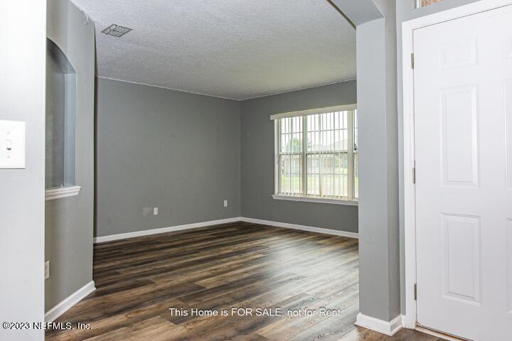 10329 Shelby Creek Road South Jacksonville, FL 32221 - Photo 5 of 41 a view of an empty room with wooden floor and a window