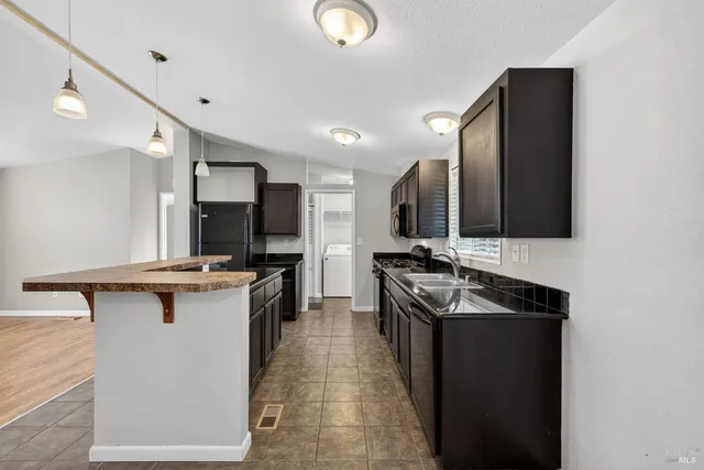 a kitchen with stainless steel appliances granite countertop a sink stove and cabinets