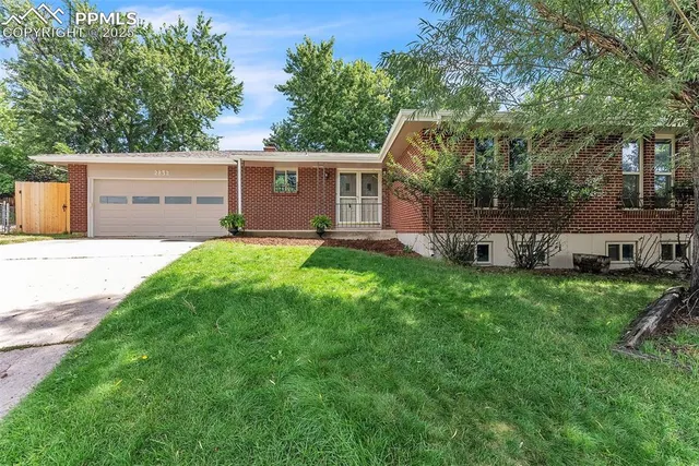 a front view of a house with a yard and trees