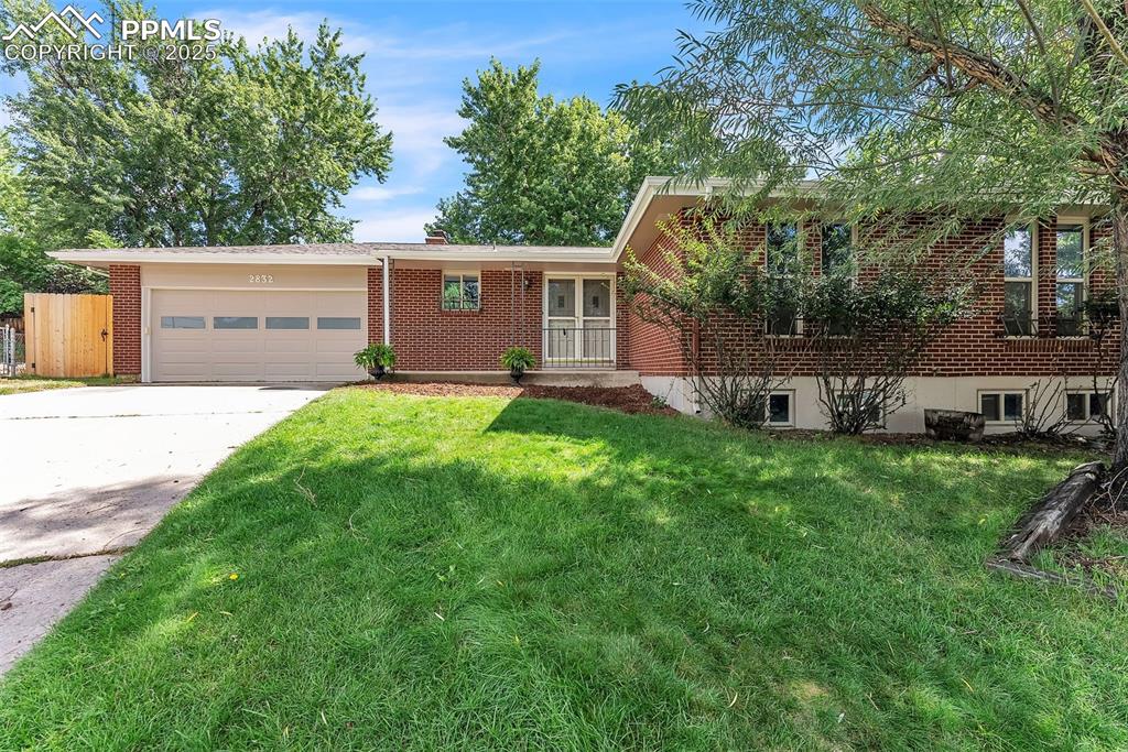 a front view of a house with a yard and trees