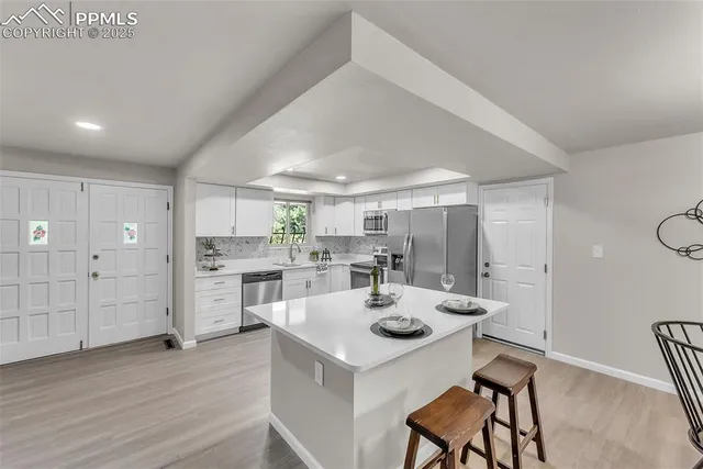 a kitchen with a sink cabinets and wooden floor