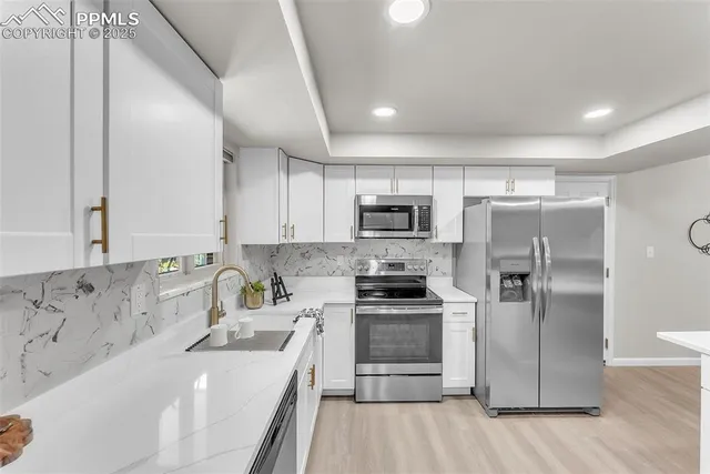 a kitchen with stainless steel appliances a refrigerator sink and microwave