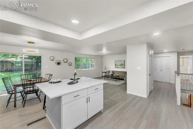 a kitchen with a sink and chairs