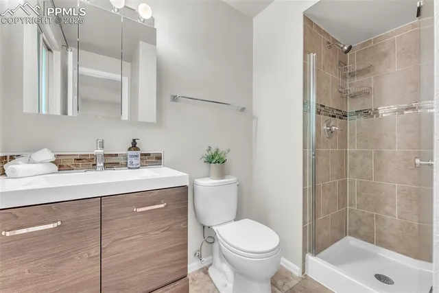 a bathroom with a granite countertop sink toilet a mirror and shower